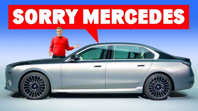 Man in red shirt stands beside a silver luxury sedan with a large red speech bubble reading 'SORRY MERCEDES'.